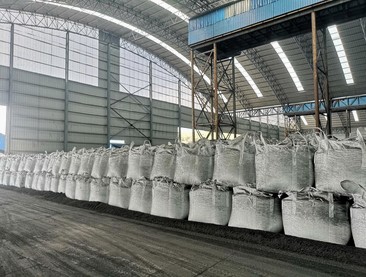 Calcined coke packed in bags on a warehouse floor